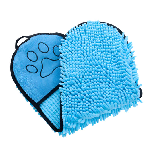 A small white dog wrapped in a blue microfiber pet towel with hand pockets, alongside rolled towels in pink and gray.