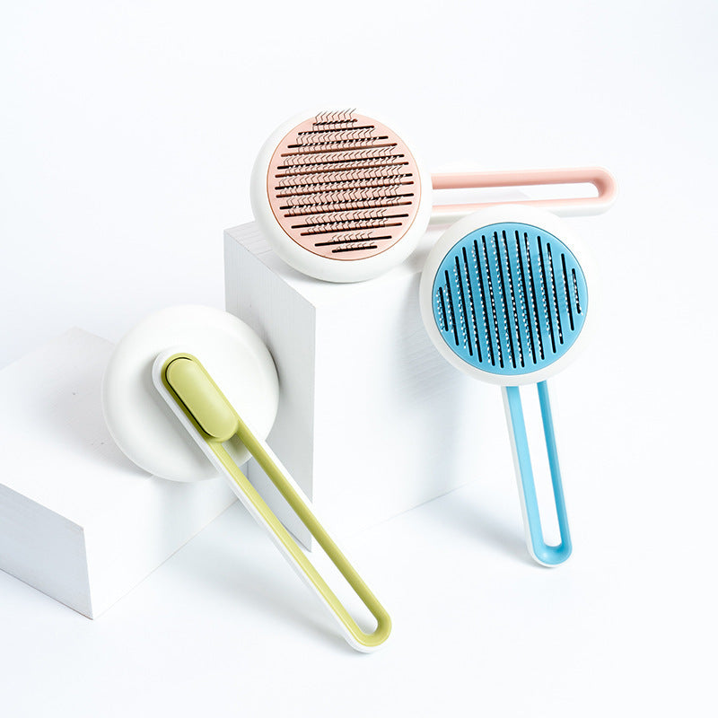 Three pet grooming brushes in different colors on a white background